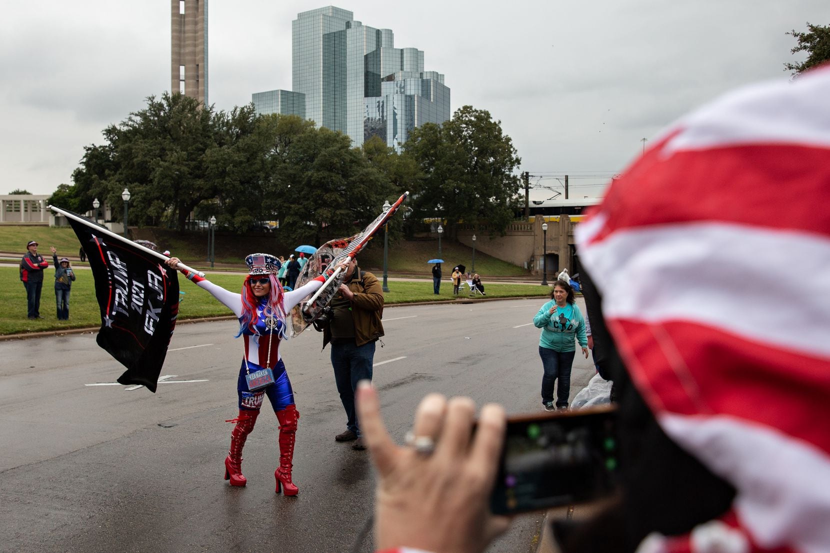 Micki Larson-Olson waves two Trump flags in the street alongside Dealey Plaza during a QAnon...