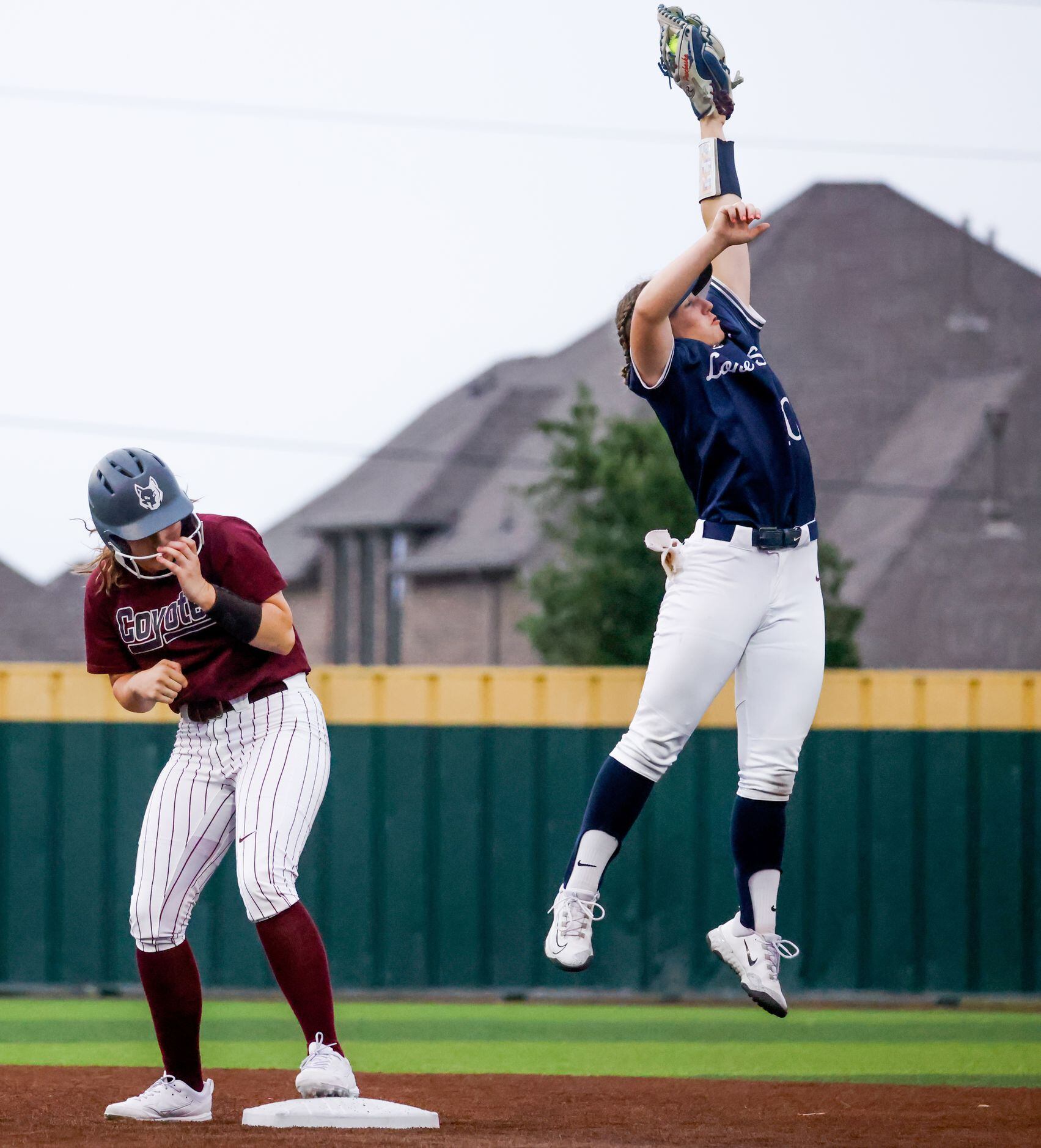 Frisco Heritage right fielder Maddy Garza (10, left) ducks for cover as Frisco Lone Star...