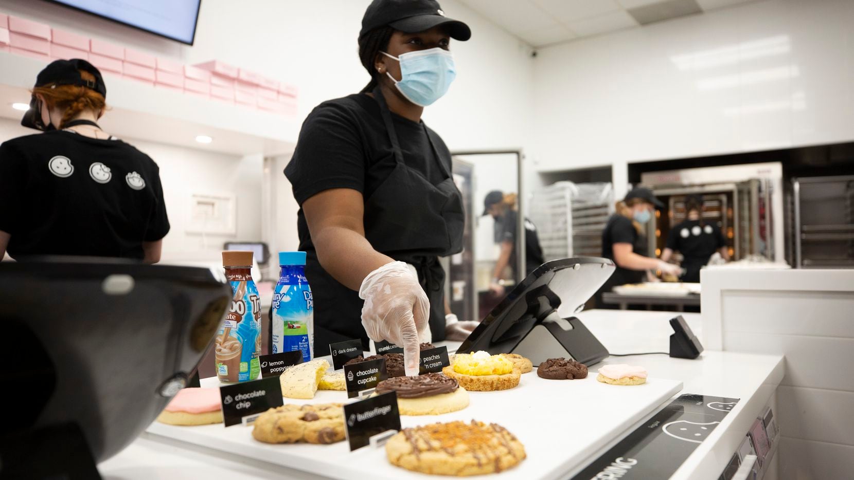 Crumbl Cookies employee Yalenny Mekondo points to one of the six cookies available that...