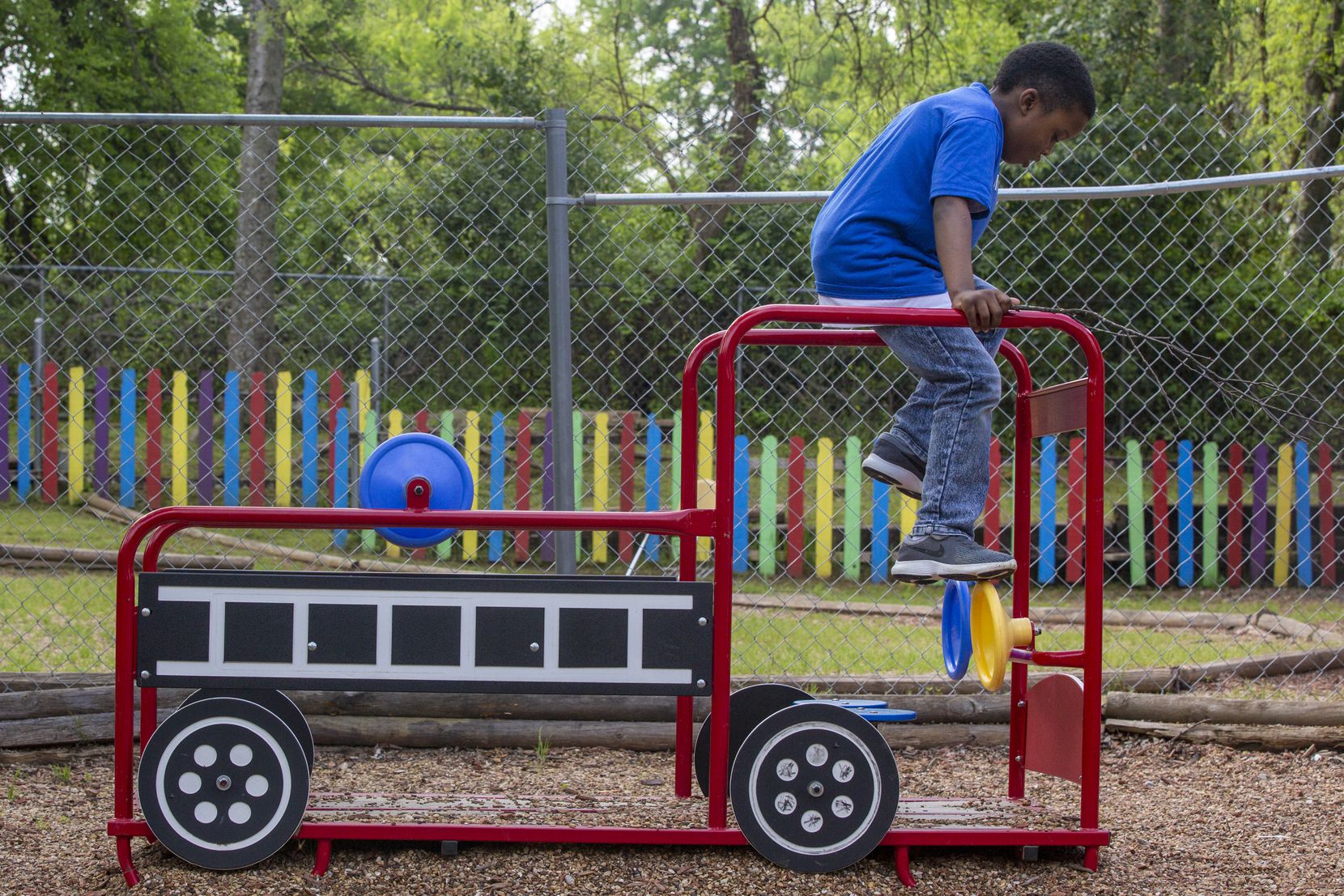 J'airus Randall, 8, plays on a fire truck toy during outdoor playtime at A Heart To Give...