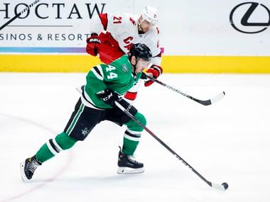 Dallas Stars defenseman Joel Hanley (44) races with the puck as Carolina Hurricanes right wing Nino Niederreiter (21) gives pursuit during the third period at the American Airlines Center in Dallas, Tuesday, April 27, 2021. The Stars lost, 5-1.