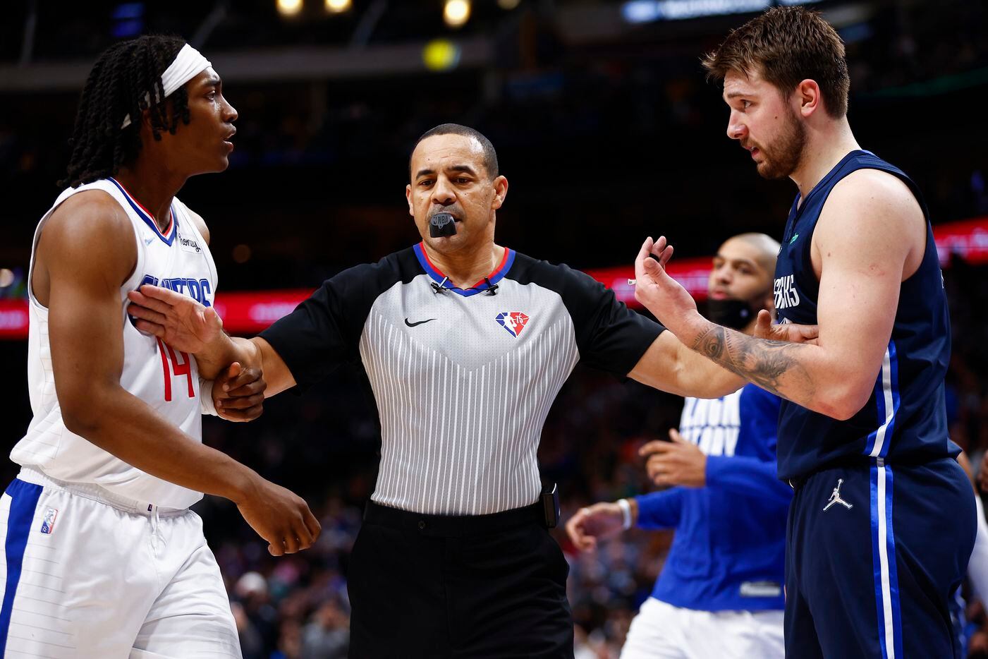 Referee Curtis Blair separates LA Clippers guard Terance Mann, left, and Dallas Mavericks guard Luka Doncic, right, after the two got in each others face during the second half of an NBA basketball game in Dallas, Saturday, February 12, 2022. LA won 99-97. 
