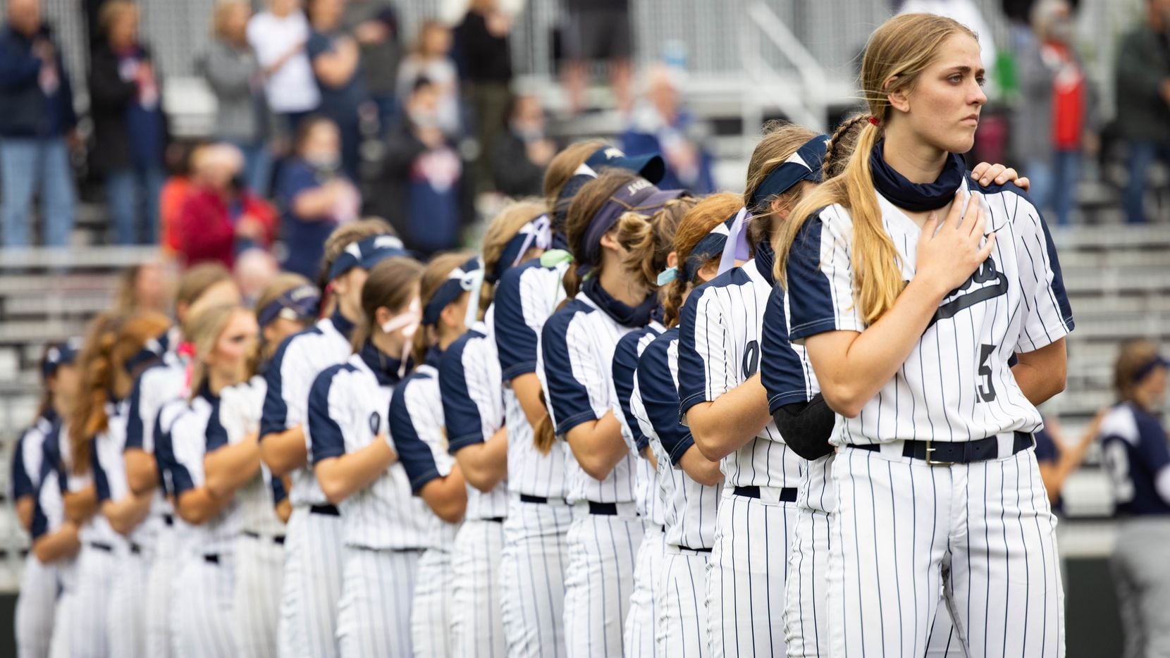 Flower Mound's pitcher Landrie Harris (15) stands with her team during the national anthem before a softball Class 6A bi-district playoff game against McKinney Boyd on Friday, April 30, 2021, in Denton.