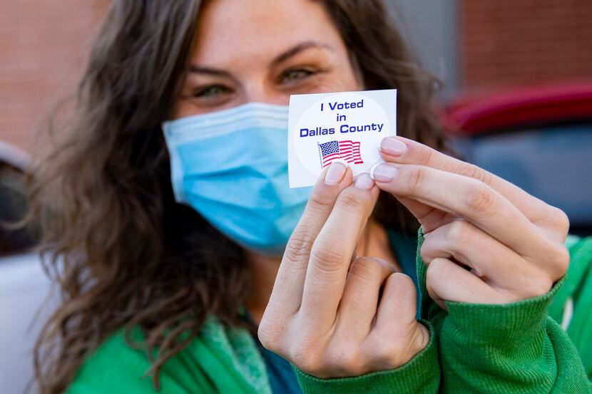 Brittney Farr poses for a photo with her 'I voted' sticker after voting during the first day...