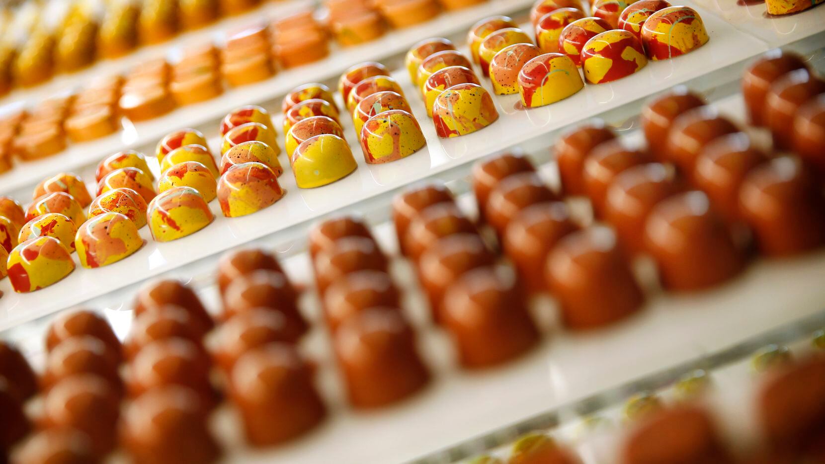 Passion Fruit (center) and other flavors of chocolate bonbons are pictured in a display case...