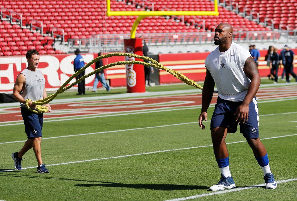 Dallas Cowboys tackle Tyron Smith (77) works with athletic trainer Britt Brown during...