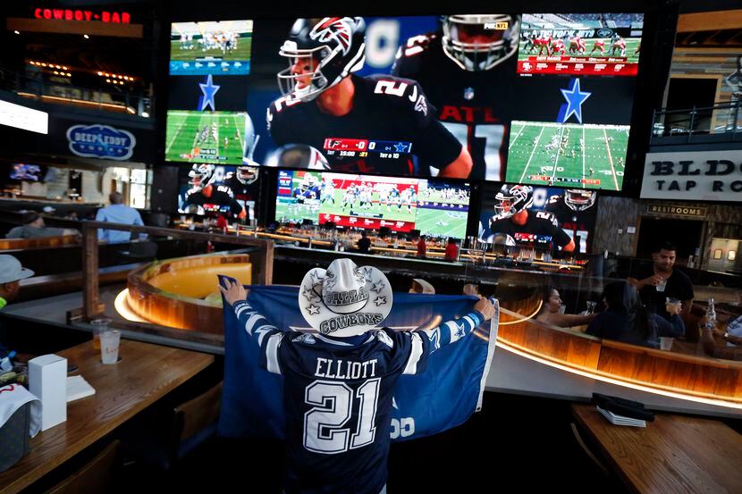 Dallas Cowboys fan Jesse Martinez of Mansfield watches a game on the large video screens at...