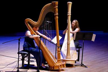 Emily Levin (left) and Michelle Gott sing while playing harps as they perform Stockhausen's...