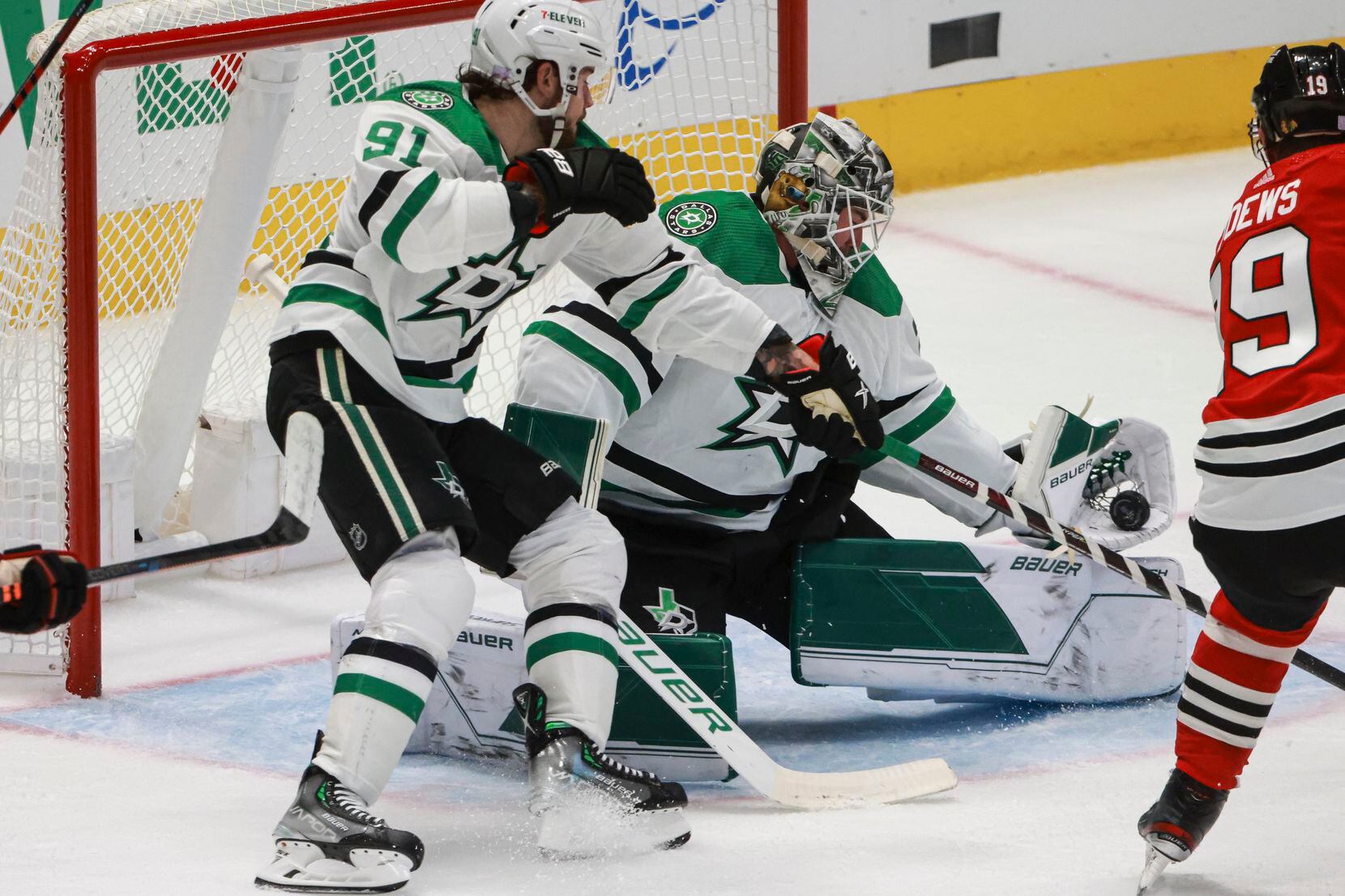 The puck slides off the glove of Dallas Stars goaltender Jake Oettinger (29) and over his...