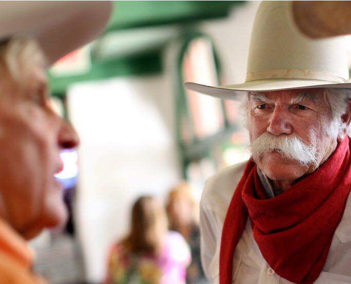 Steve Murrin talks with fellow cowboys and friends at the ribbon cutting celebration for the...