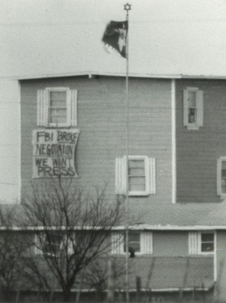 People inside the compound lowered a banner outside a window on March 14, 1993, that read,...