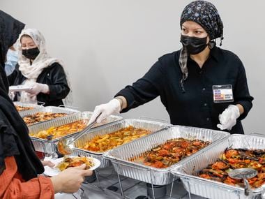 Jamileh Jafari serves food to Afghan evacuees at Catholic Charities Dallas on Dec. 22. Break Bread, Break Borders is a nonprofit that worked with Catholic Charities to host a lunch for recent Afghan arrivals in the Dallas area.