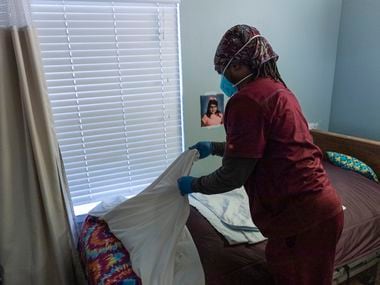 Certified nurse assistant Okeibunov Iweze prepares a resident’s bed before helping a resident back to her bed at Focused Care at Waxahachie in Waxahachie, Tuesday, January 18, 2022. Since November 14 staff members and four residents have tested positive for COVID-19. 