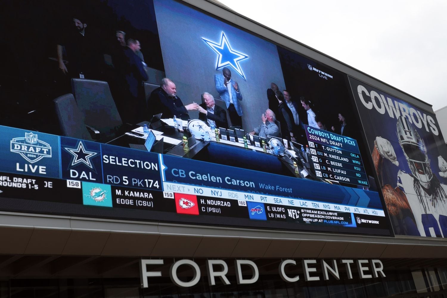 A large video screen over the entrance doors to Ford Center projects Dallas Cowboys owner...