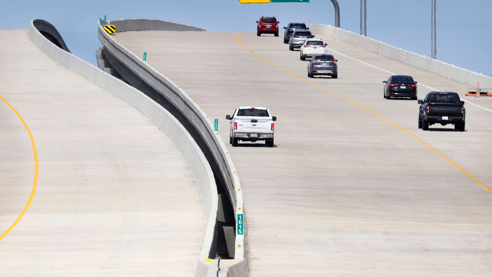 Northbound traffic on the Dallas North Tollway (right) climbs the newly opened bridge over...