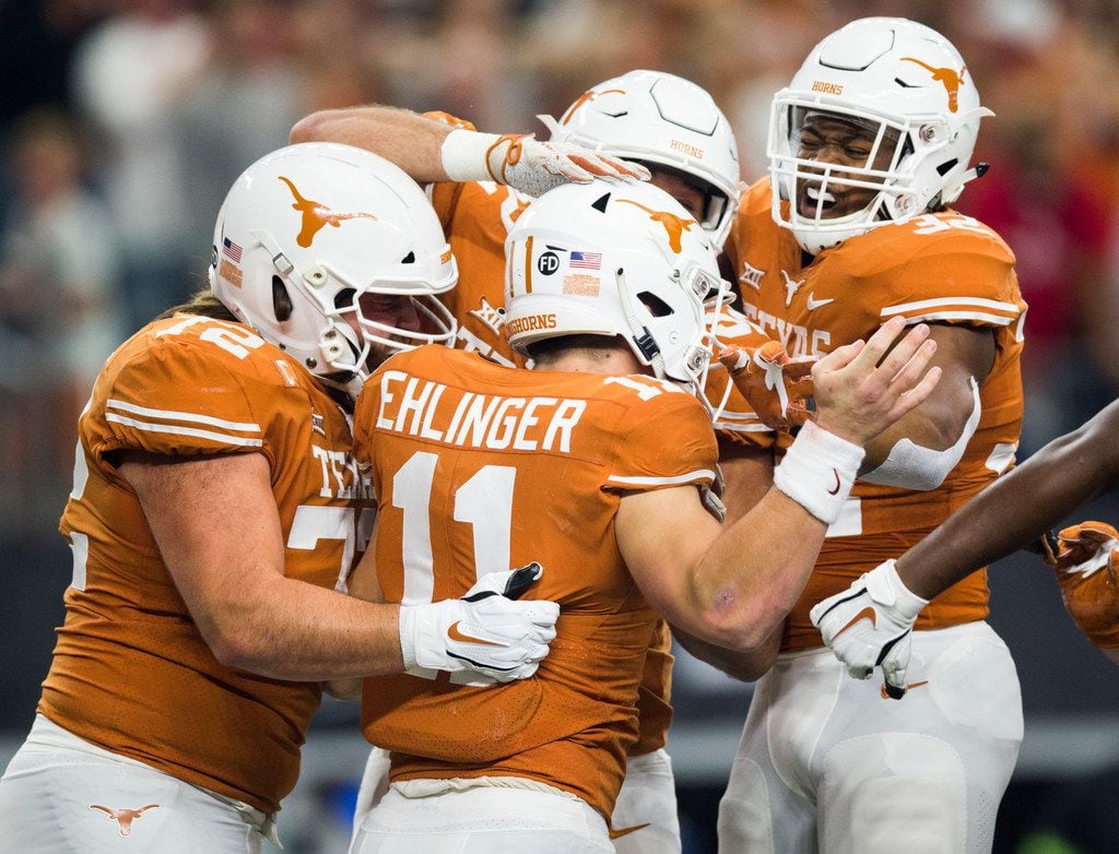 FILE - Texas Longhorns quarterback Sam Ehlinger (11) celebrates with team mates in the...