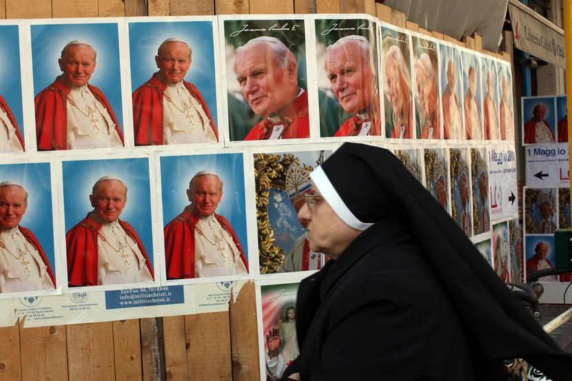 Una monja observa rótulos con la imagen del Papa Juan Pablo II, durante las ceremonias de...