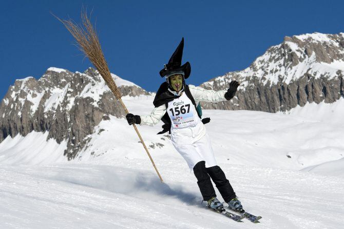 A skier disguised as witches participates in the 30th ski downhill race at ...