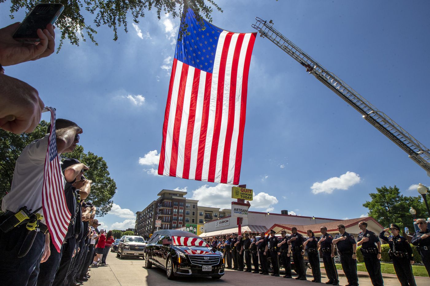 Plano police and first responders salute as the hearse carrying the body of Congressman...