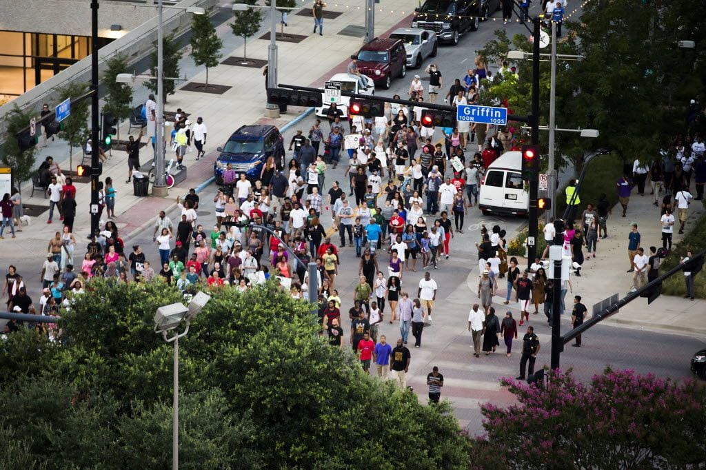 Demonstrators in Black Lives Matter march pass through the intersection of Main and Griffin...