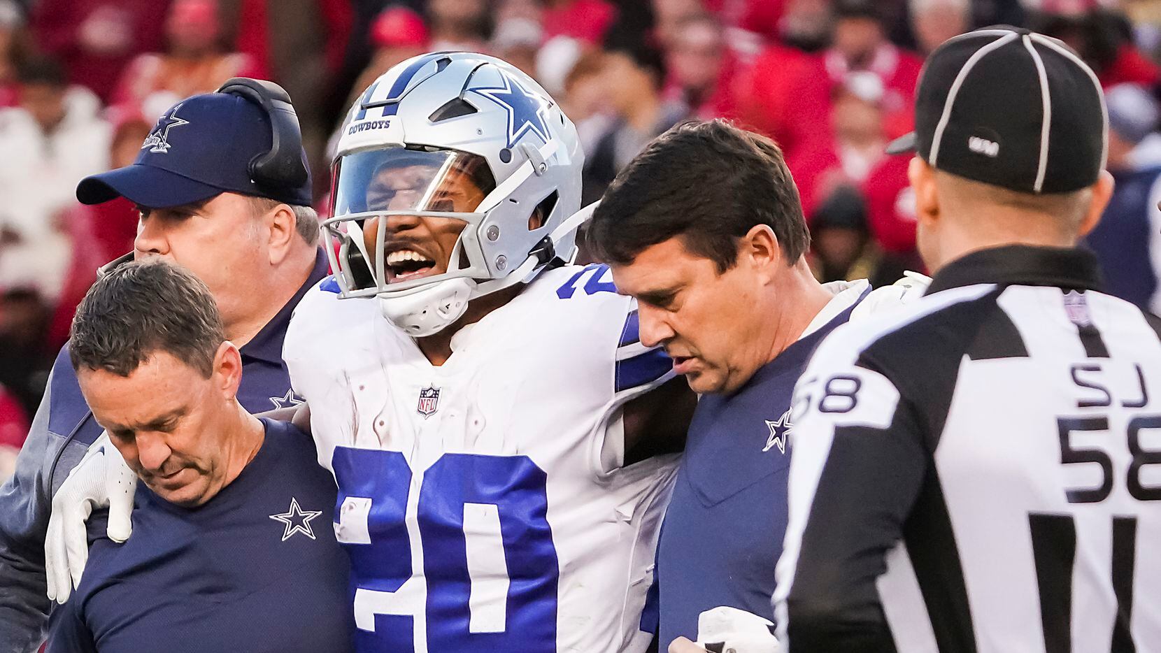 Dallas Cowboys running back Tony Pollard (20) grimaces as he leaves the field after being...