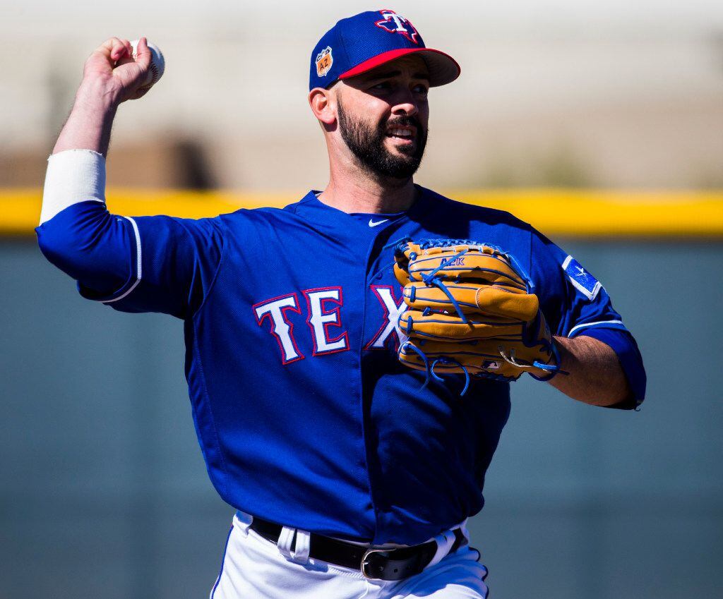 Texas Rangers starting pitcher Dillon Gee (36) throws to first base during a workout at the...