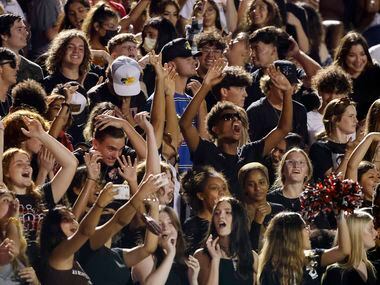 The Euless Trinity student section cheers during the first half of their high school...