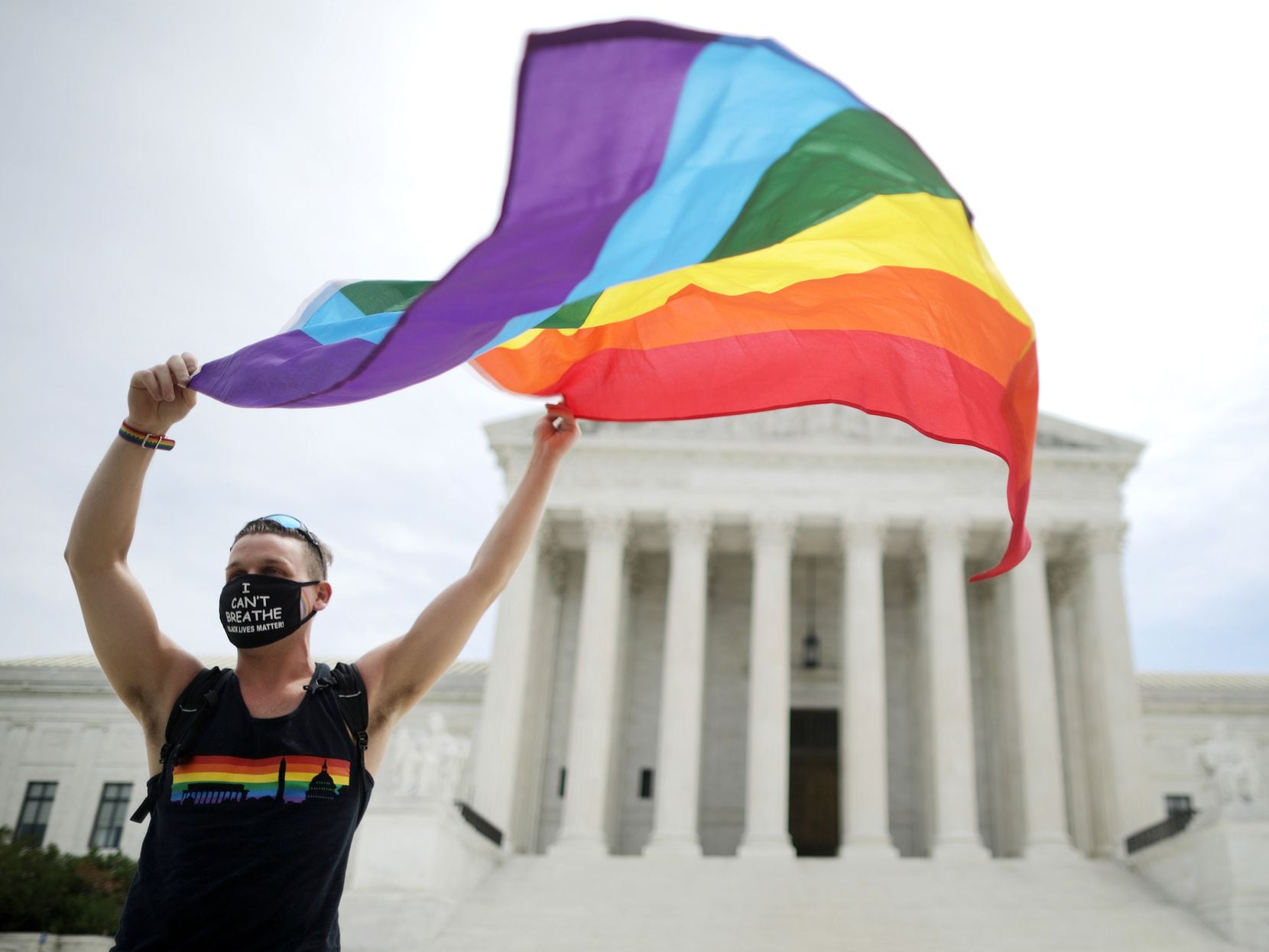Joseph Fons, holding a Pride Flag, stands in front of the U.S. Supreme Court building after the court ruled that LGBTQ people can not be disciplined or fired based on their sexual orientation June 15, 2020 in Washington, DC. With Chief Justice John Roberts and Justice Neil Gorsuch joining the Democratic appointees, the court ruled 6-3 that the Civil Rights Act of 1964 bans bias based on sexual orientation or gender identity.