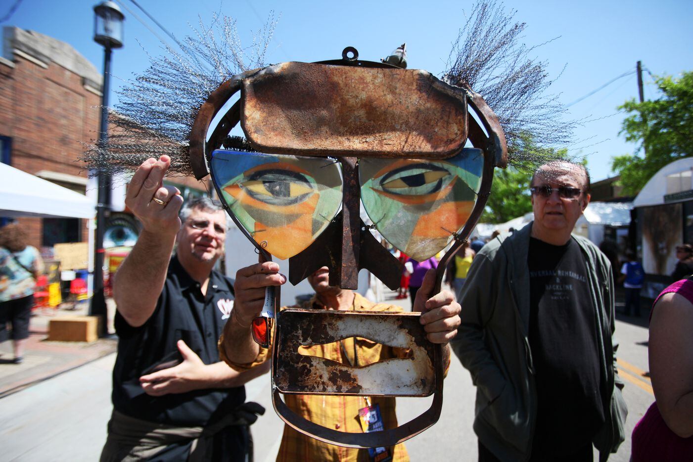Artist Mitch Berg, of Santa Fe, New Mexico, holds a piece of his own work as he attempts to...