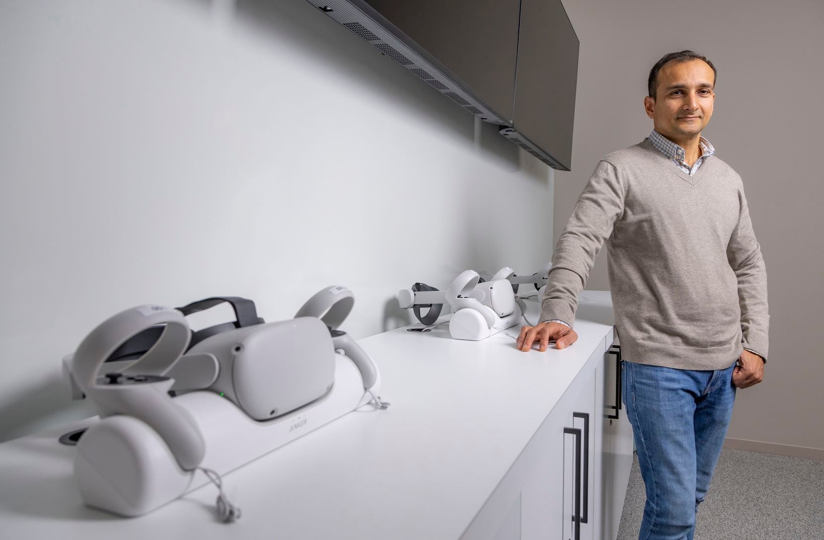 Sandeep Davé pose avec des casques de réalité virtuelle qui peuvent être utilisés pour l'intégration et...