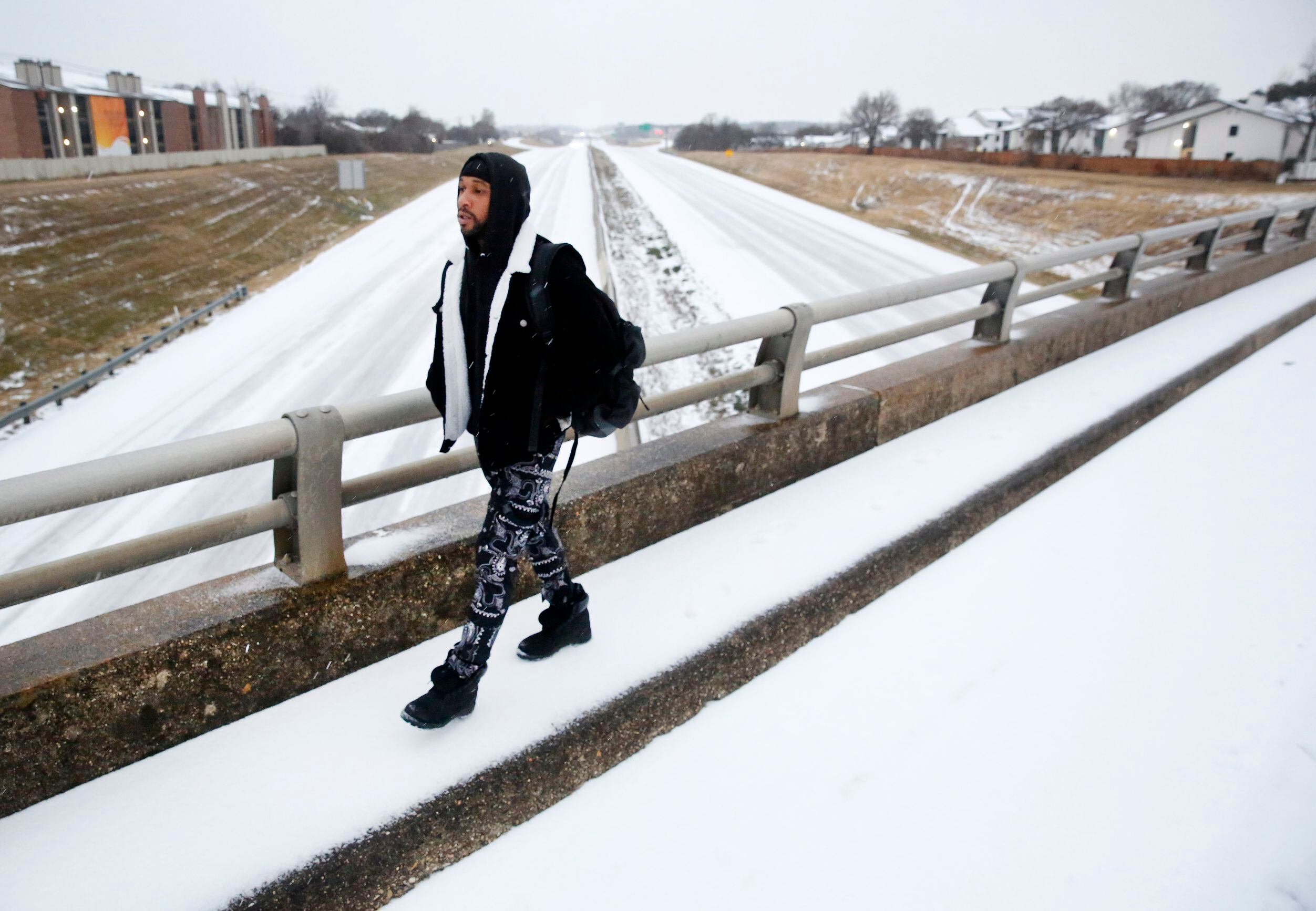 Steven Caldwell crosses a sleet covered bridge over Interstate 30 as he makes his way to the...