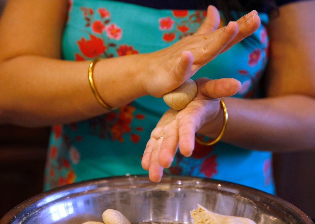 Sapna Punjabi-Gupta rolls out ball of dough prior to cooking roti.