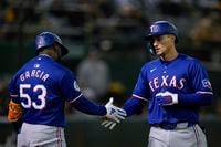 Texas Rangers' Corey Seager, right, celebrates with Adolis García, right, after hitting a...