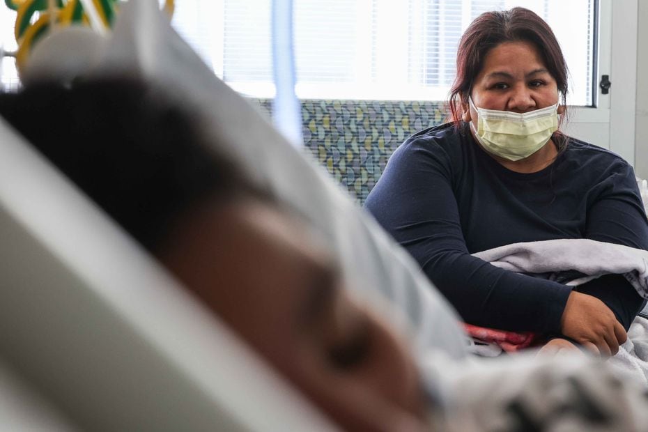 Yessica Gonzalez, 42, looks at her son, Francisco Rosales, 9, who lies in a pediatric intensive care unit bed with COVID-19 at Children's Medical Center Dallas on Friday, Aug. 13, 2021. Gonzalez, who is vaccinated, also got COVID, but her symptoms have been mild. (Lola Gomez/The Dallas Morning News)