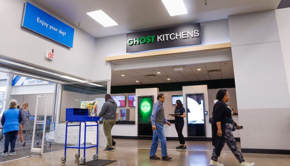 Walmart customers walk past a space-age-looking Ghost Kitchen Brands restaurant near the...