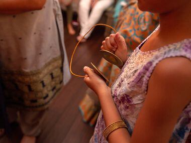 Mihika Gupta, 9, uses a percussion instrument during a Ganesha Chaturthi celebration.