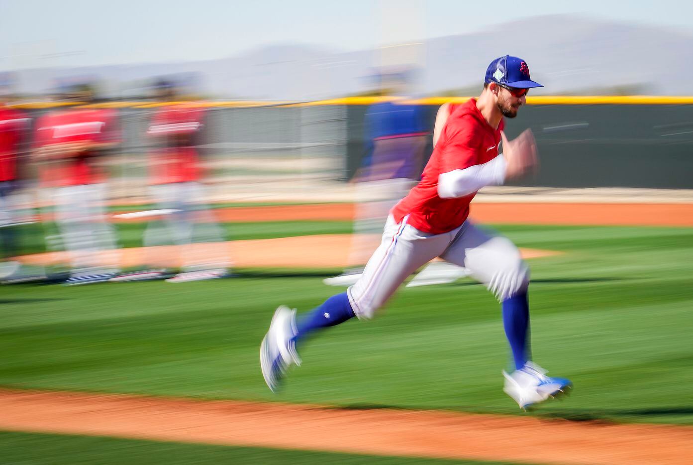 Texas Rangers outfielder Eli White participates in a base running drill during a spring...