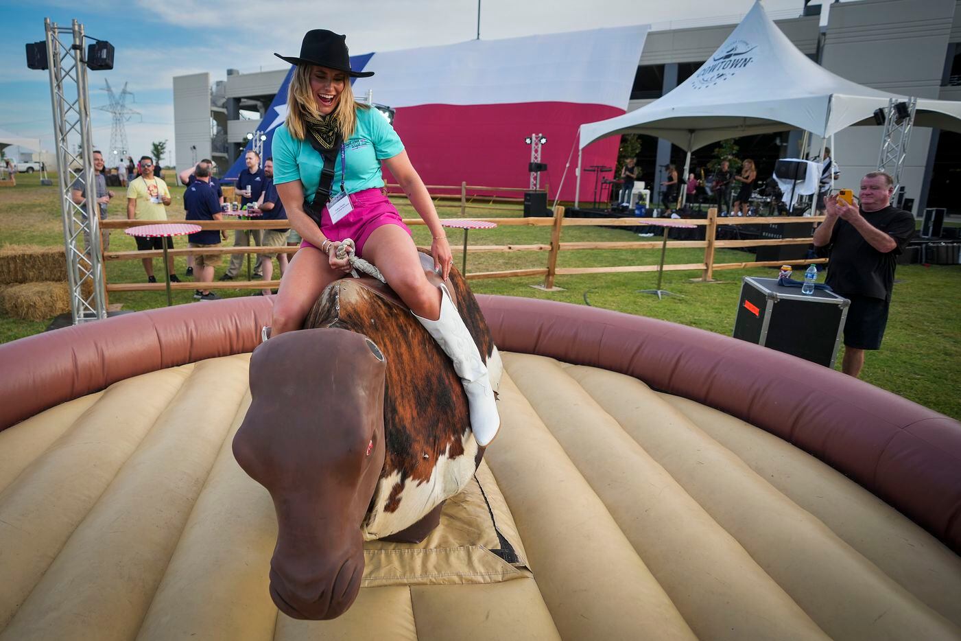 Shelby Hooks, senior manager corporate talent selection, rides a mechanical bull during the...
