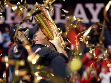 Under a hail of confetti, Georgia Bulldogs head coach Kirby Smart kisses the CFP National...