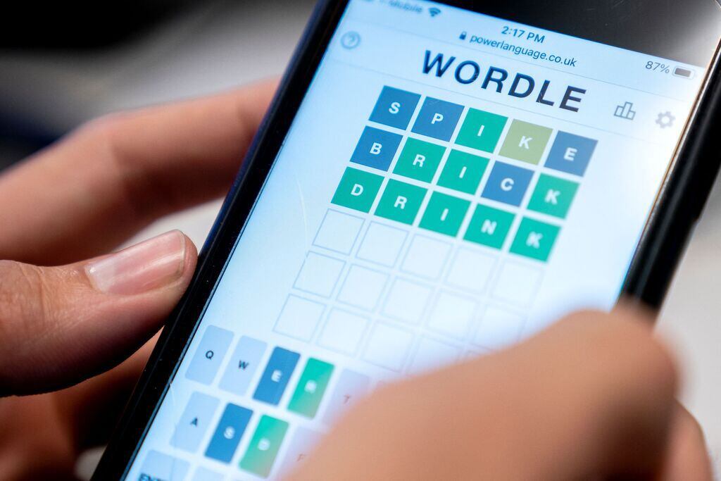 This photo illustration shows a person playing online word game Wordle on a mobile phone.