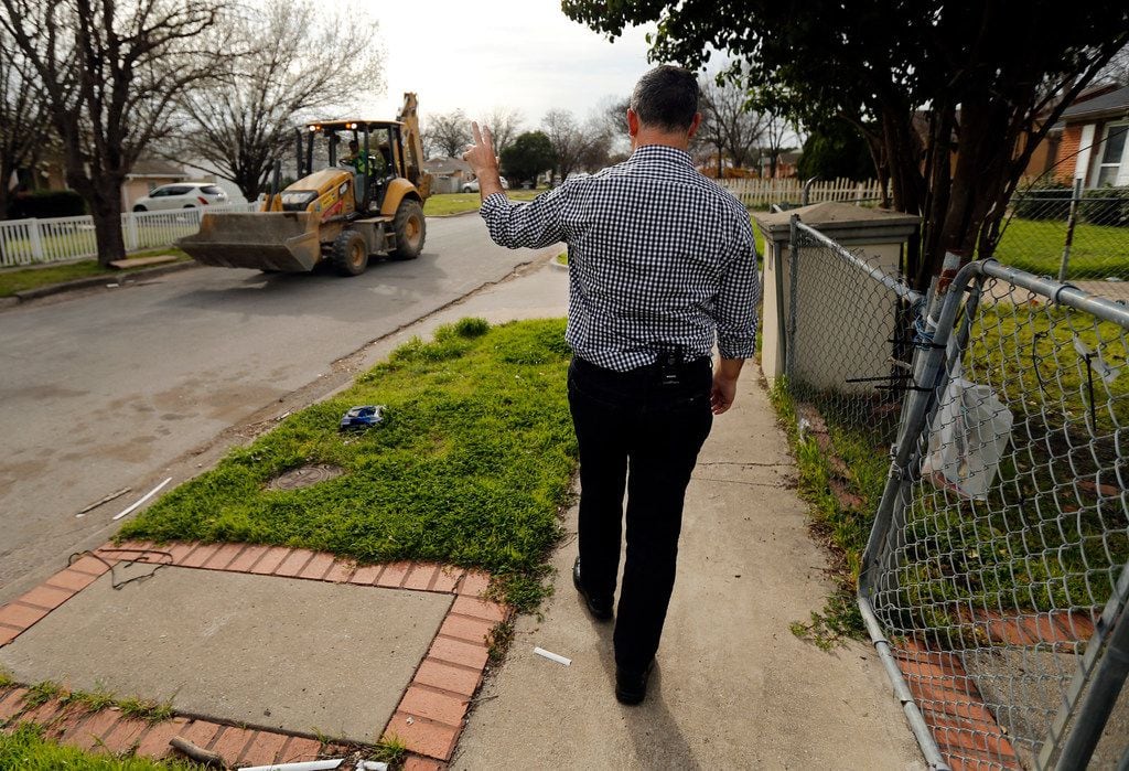 Rep. Rafael Anchia waves to a backhoe operator as he walks the Northwest Dallas neighborhood...