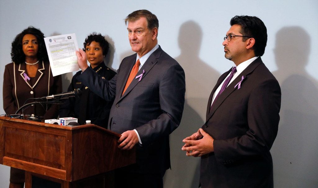 Dallas Mayor Mike Rawlings, third from left, holds a copy of the Domestic Violence Lethality...