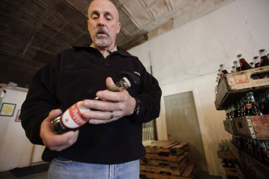 Jeff Kloster, owner of Dublin Bottling Works, looks over one of the last bottles of Dr...