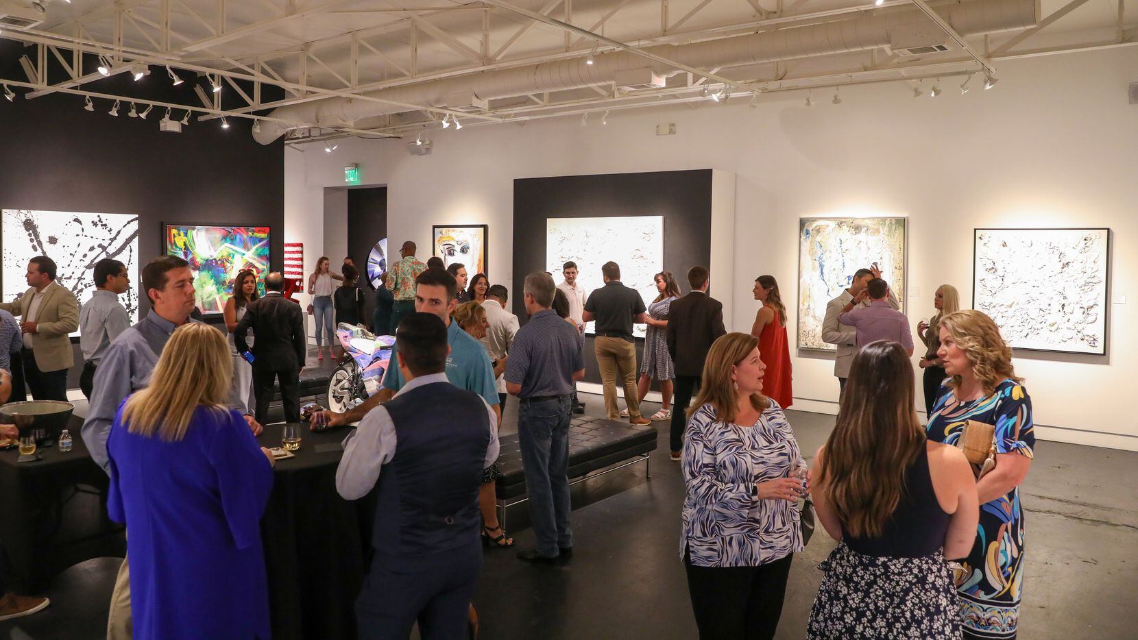 New York Life staffers sip wine and look at art at the Samuel Lynne Galleries in Dallas at a...