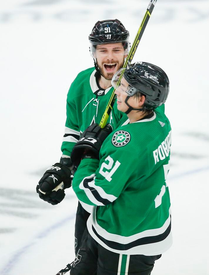 Dallas Stars forward Jason Robertson (21) is congratulated by forward Tyler Seguin (91) after scoring an empty net goal during the third period of an NHL hockey game against the Detroit Red Wings, Tuesday, November 16, 2021. Dallas won 5-2. (Brandon Wade/Special Contributor)
