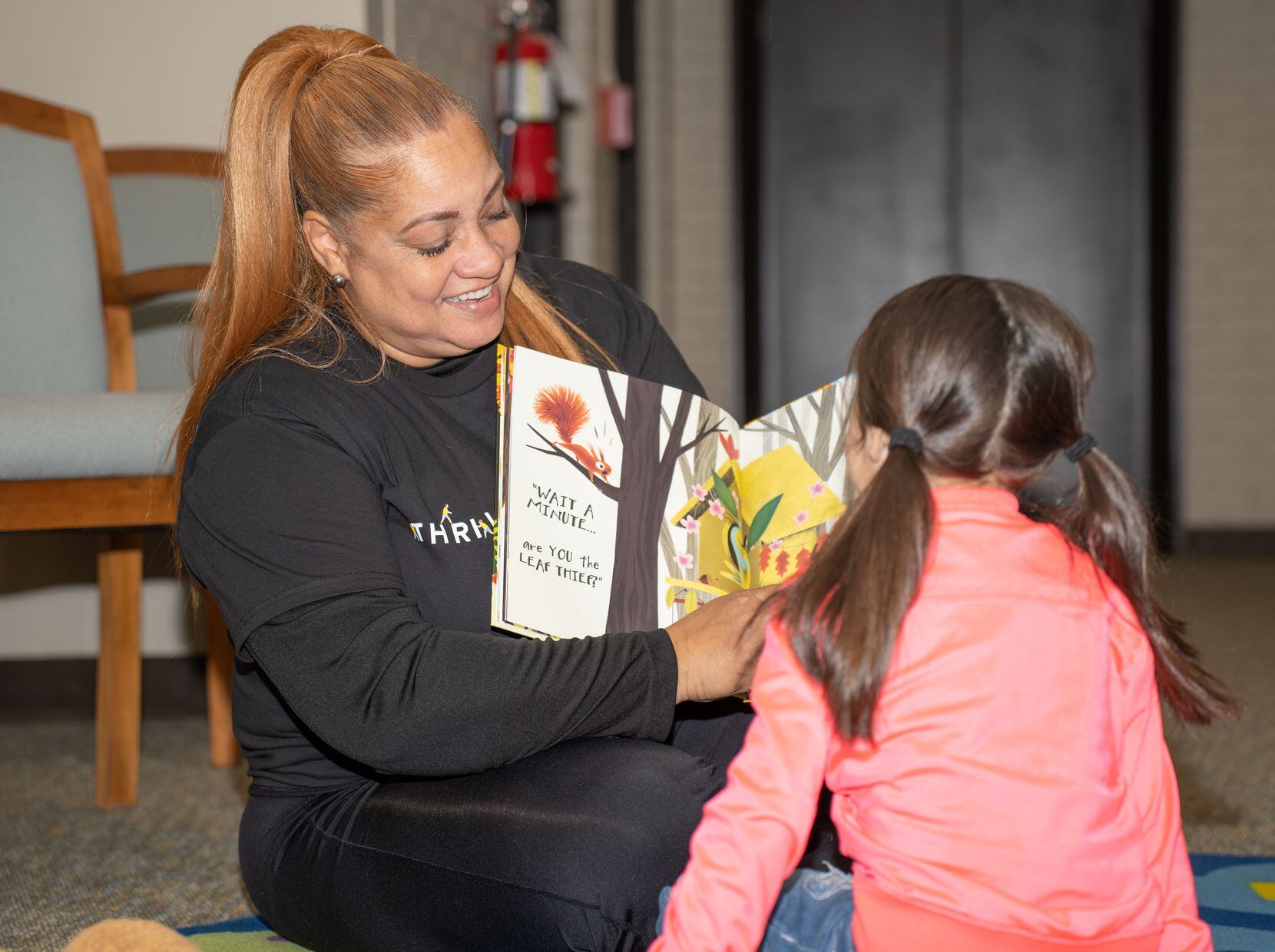 Frito-Lay employee reads a book to a child during their Day of Caring event.