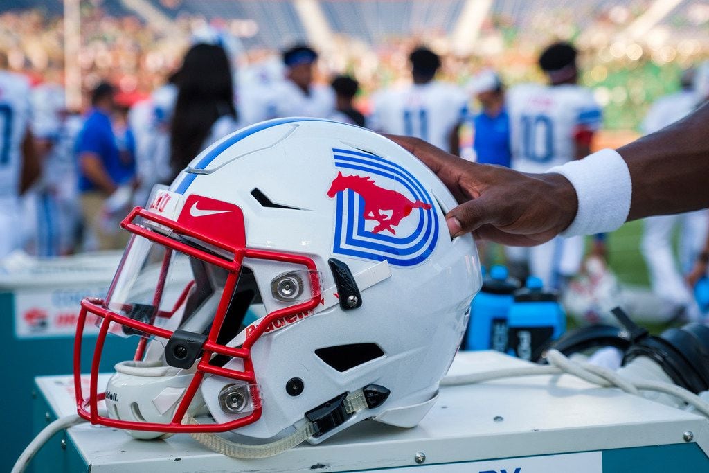 A SMU player grabs his helmet before an NCAA football game against UNT at Ford Stadium on Saturday, Sept. 7, 2019, in Dallas.