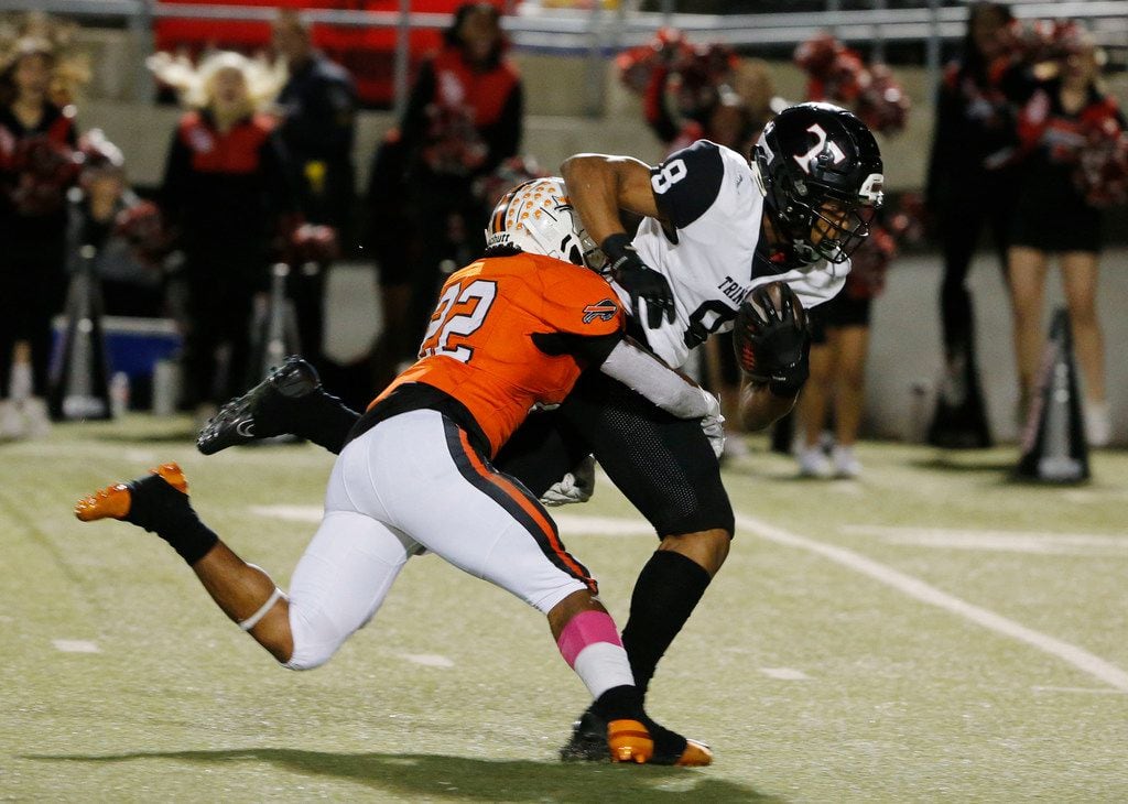 Trinity receiver Camryn Hardy (8) makes a catch and is tackled by Haltom's Johnny...