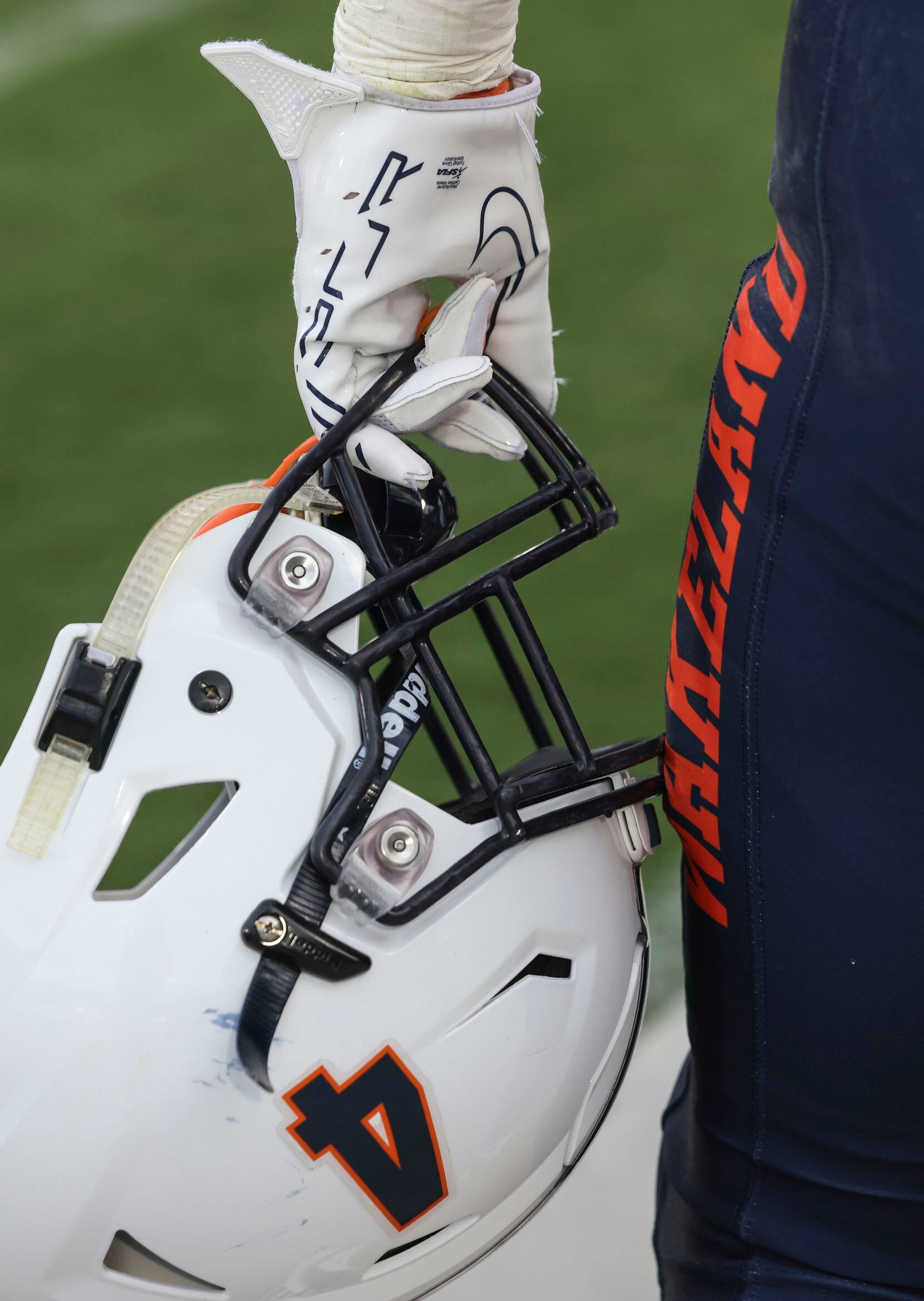 Wakeland High School’s Cooper Snyder holds his helmet in his hand while watching the play...
