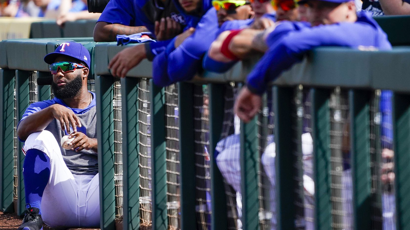 Texas Rangers outfielder Danny Santana takes in the action from the top of the dugout steps...